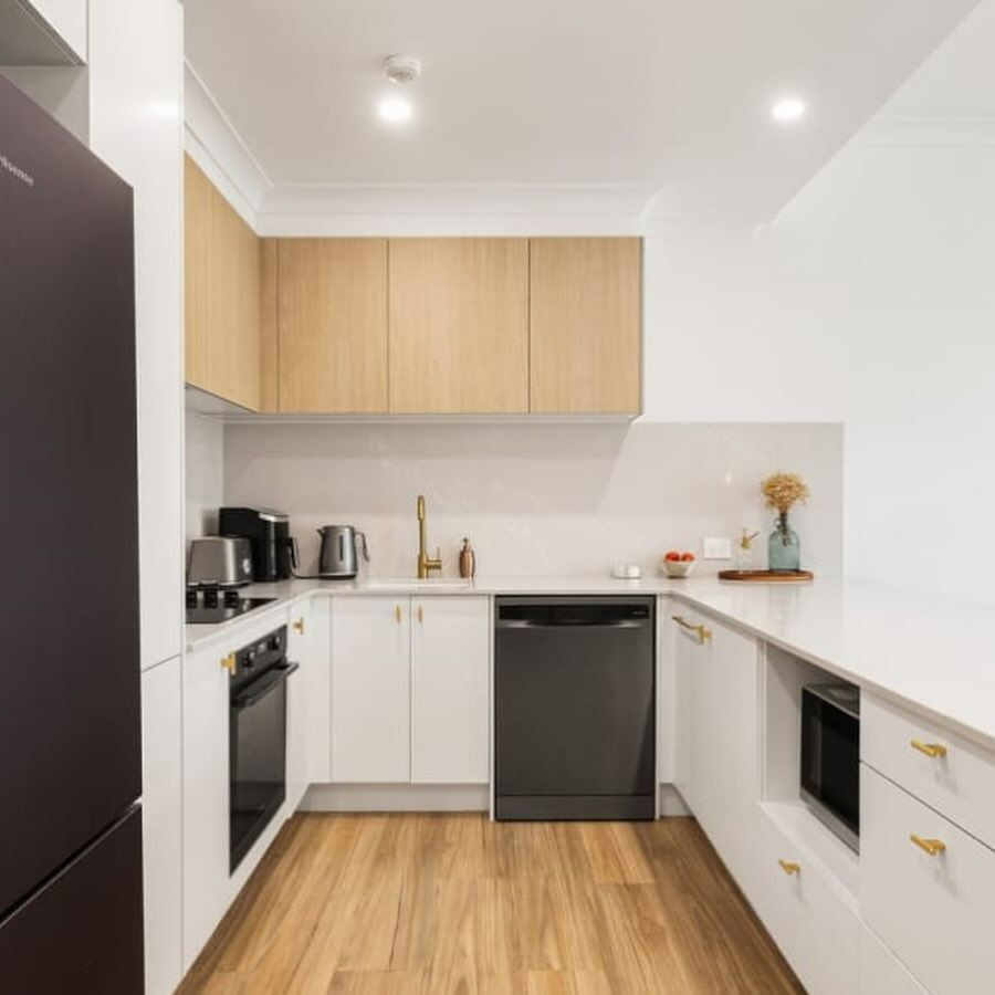 Modern U-shaped Kitchen With Light Wood Cabinets, White Countertops and Appliances, and Black Fridge — Zero 21 Fit-Outs & Joinery: Kitchen Renovation Gold Coast in Molendinar, QLD