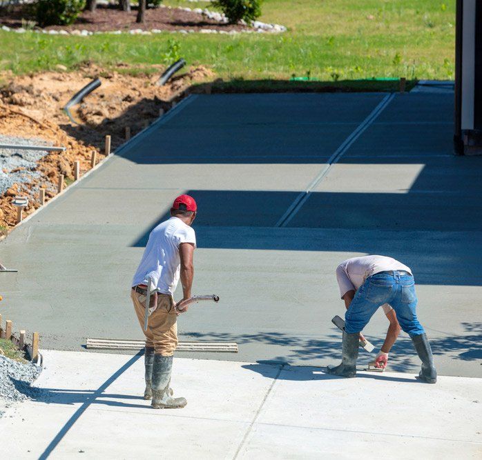 Men Working On A New Concrete Driveway At A Residential Home — Maitland Concreting Specialists In Singleton NSW