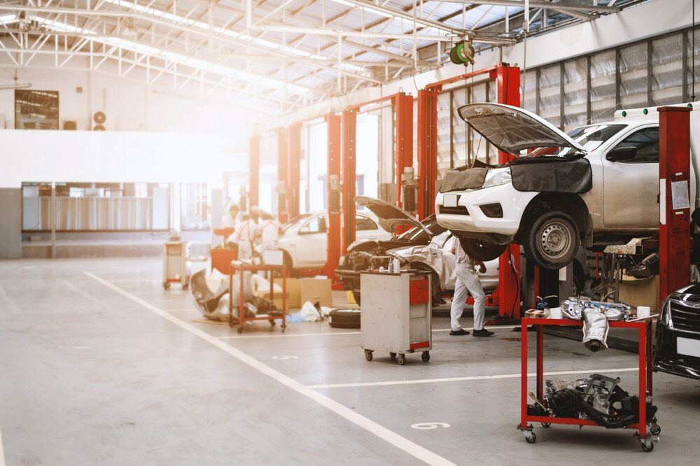 Cars on Lifts in a Brightly Lit Auto Repair Shop, Mechanics Working — Mullumbimby Auto Electrical in Mullumbimby, NSW