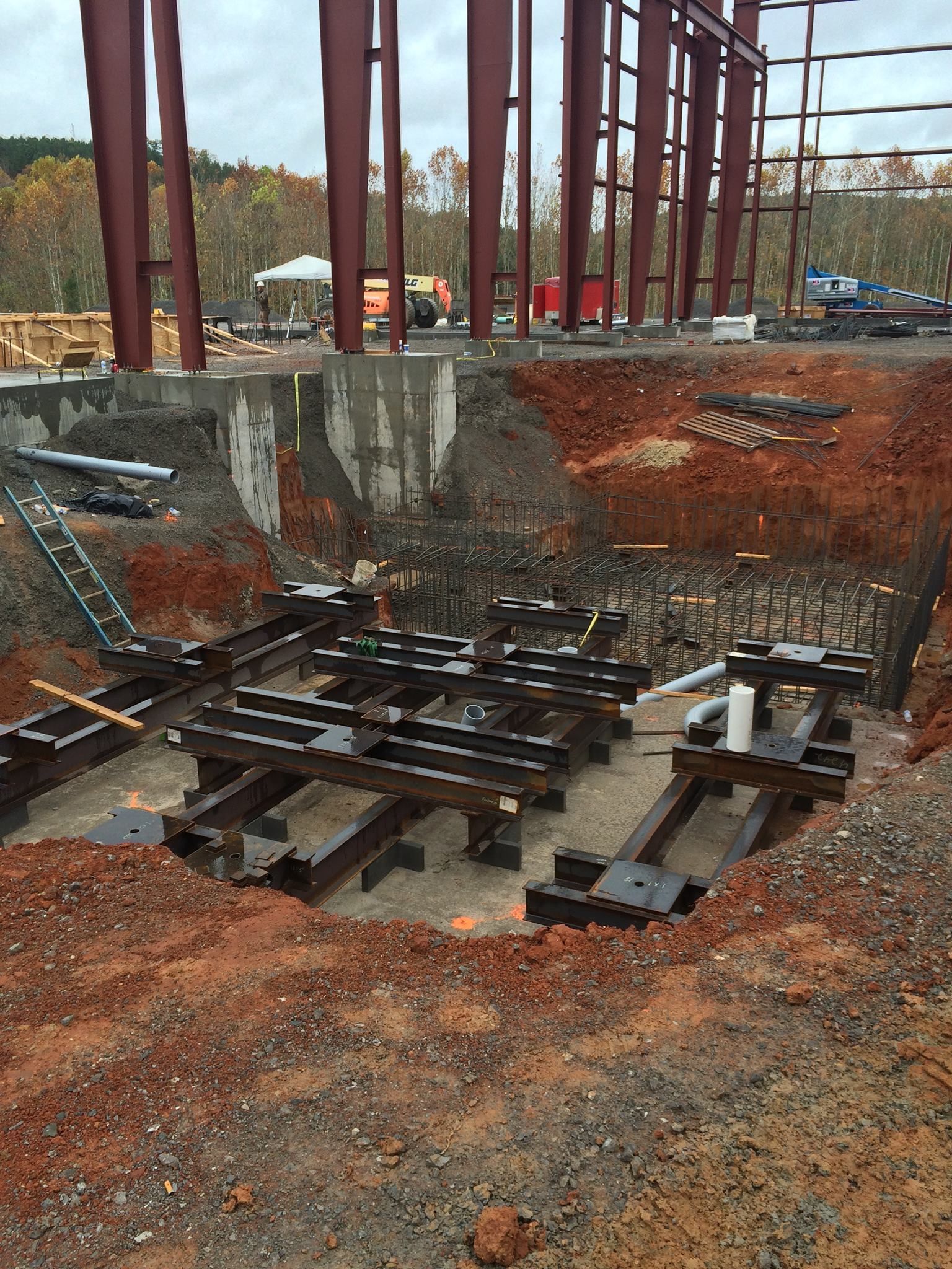 A construction site with a lot of metal pieces in the dirt.