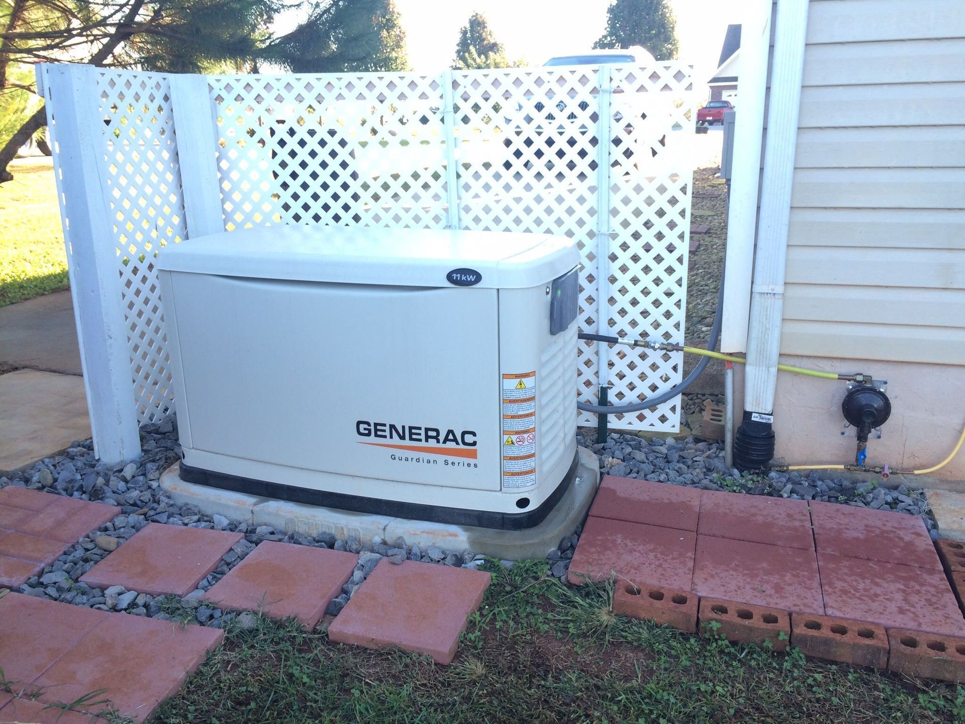 A generac generator is sitting on the side of a house.