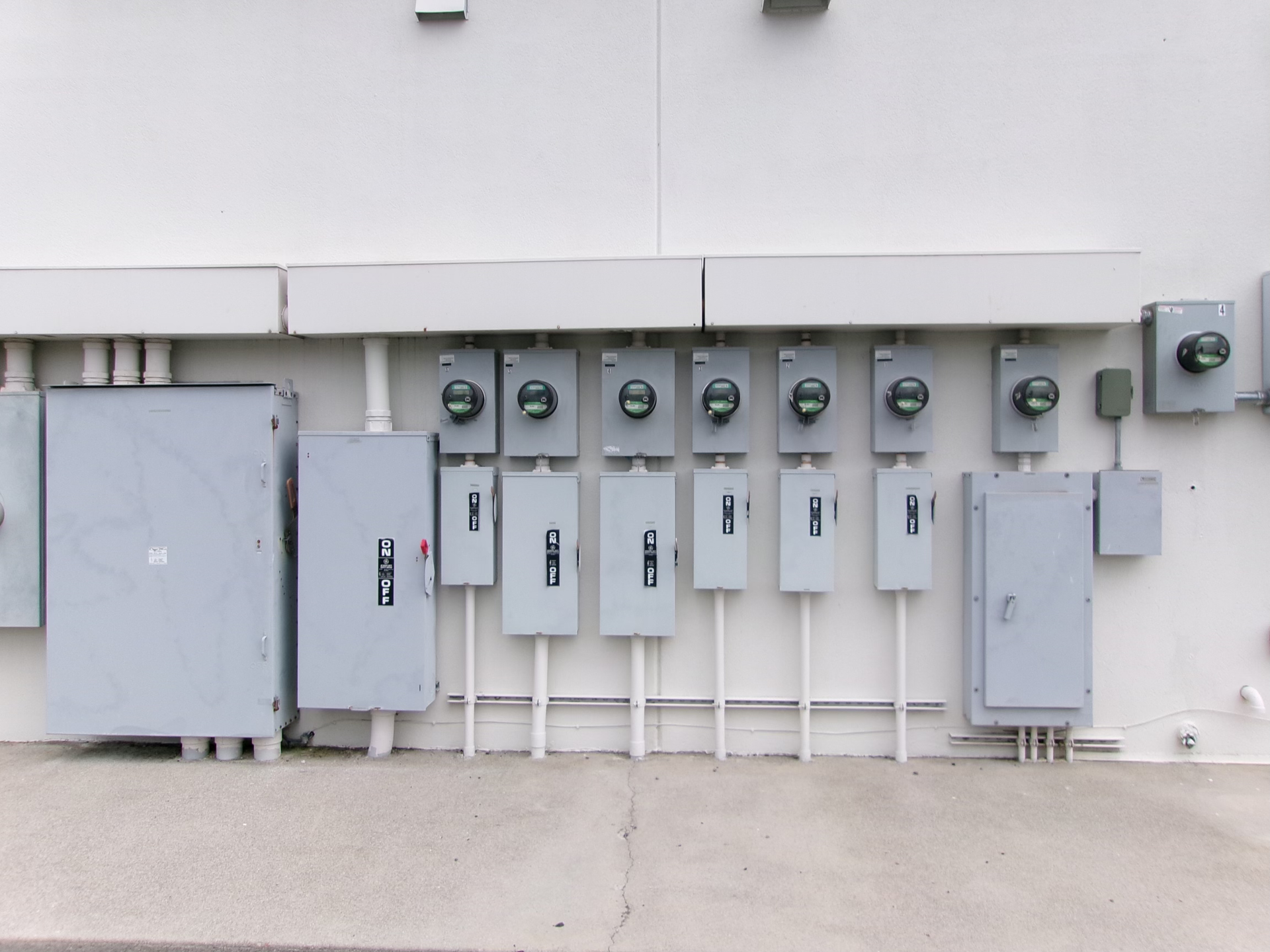 A row of electrical boxes on the side of a building