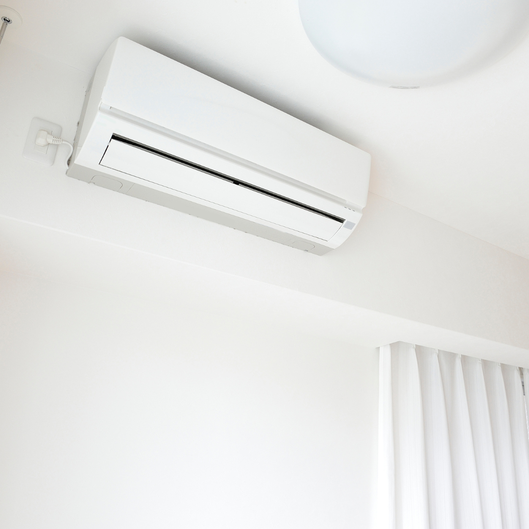 A white air conditioner is hanging from the ceiling in a room