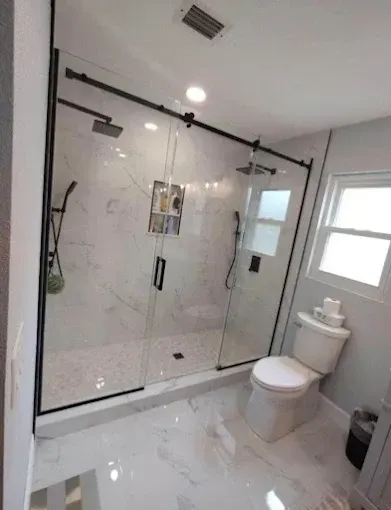 Modern bathroom with a glass shower enclosure and a white toilet.