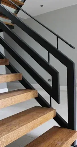 Wooden staircase with black metal railing.