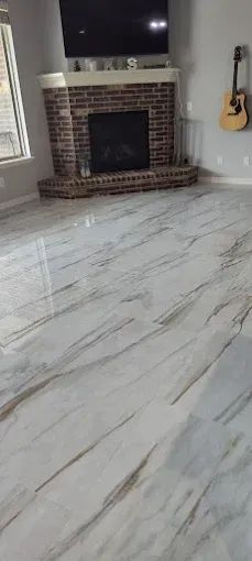 Living room with marble-patterned flooring, brick fireplace, and a guitar on the wall.