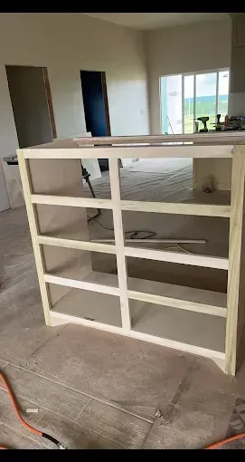 Wooden kitchen cabinet frame under construction, indoors.