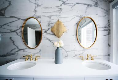 sink and mirror with tiling in the bathroom wall.