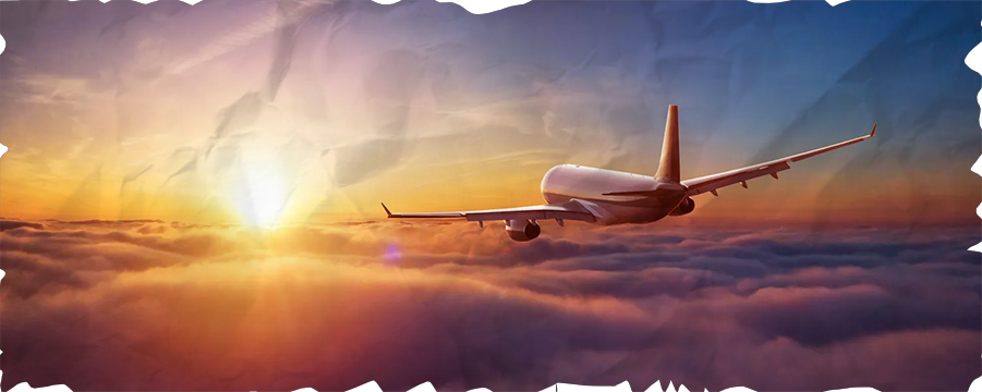 An airplane is flying through the clouds at sunset.