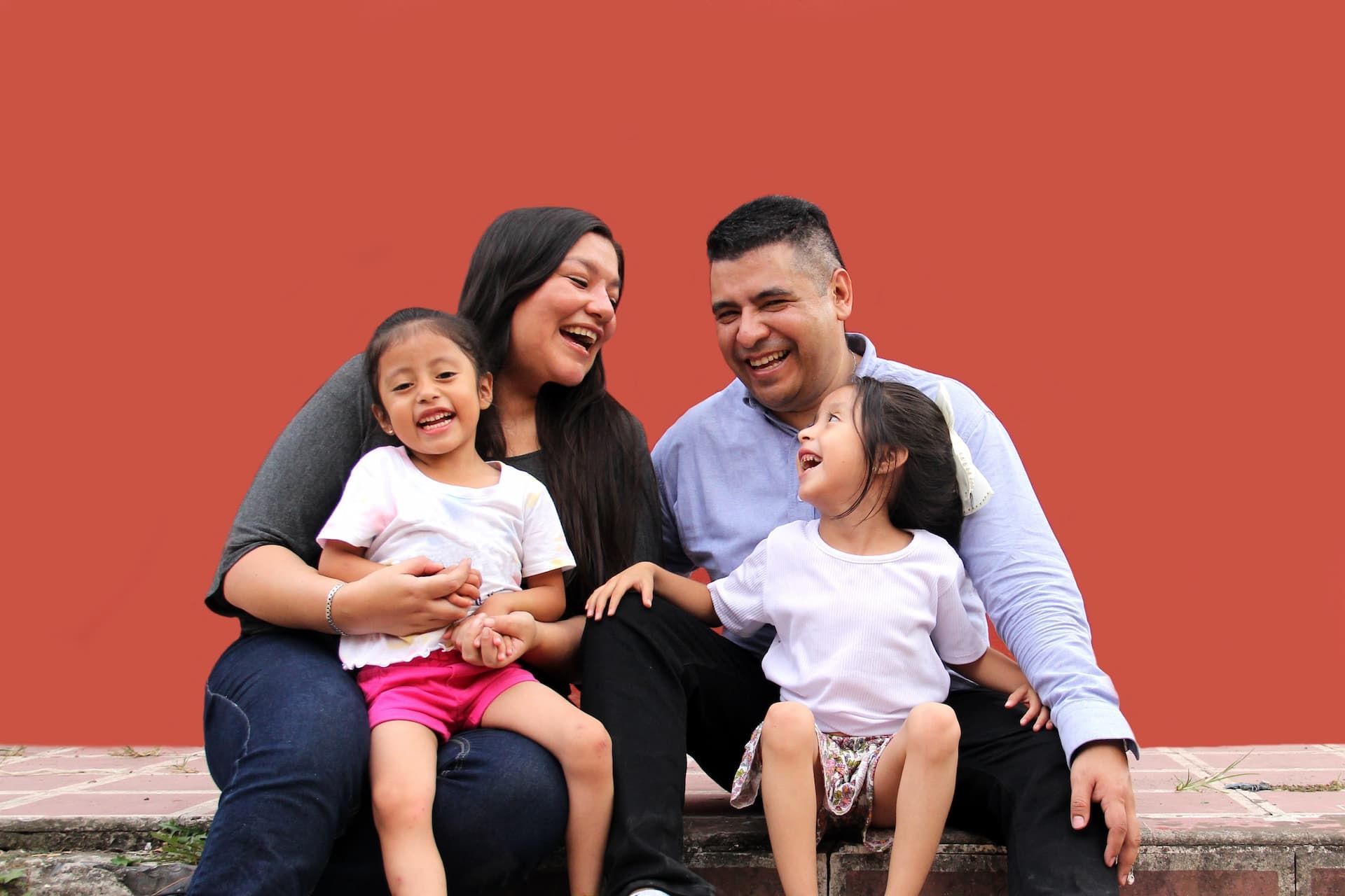 Image of a young family sitting and laughing together