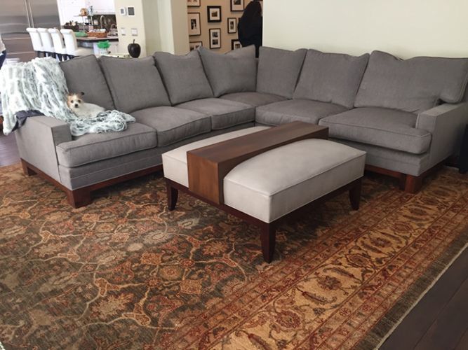 A dog is laying on a couch next to a coffee table.