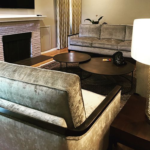 A living room with a couch, chair, coffee table and fireplace.