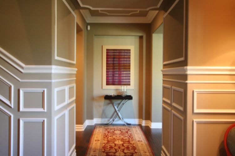 A hallway with a rug and a picture on the wall.