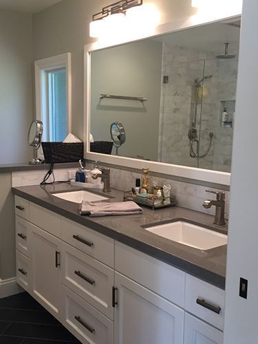 A bathroom with two sinks and a large mirror.