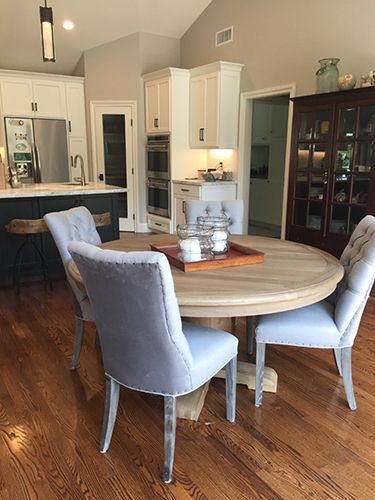 A kitchen with a round table and chairs in it.