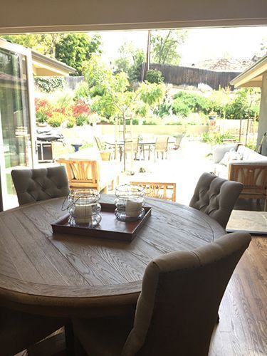 A dining room table with a tray of candles on it.