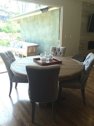 A dining room table with chairs and a tray of candles on it.