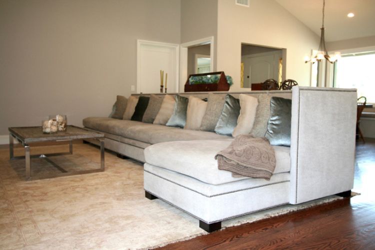 A living room with a large sectional couch and a coffee table.