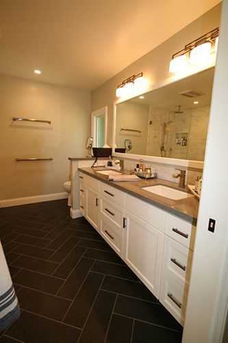 A bathroom with two sinks and a large mirror.