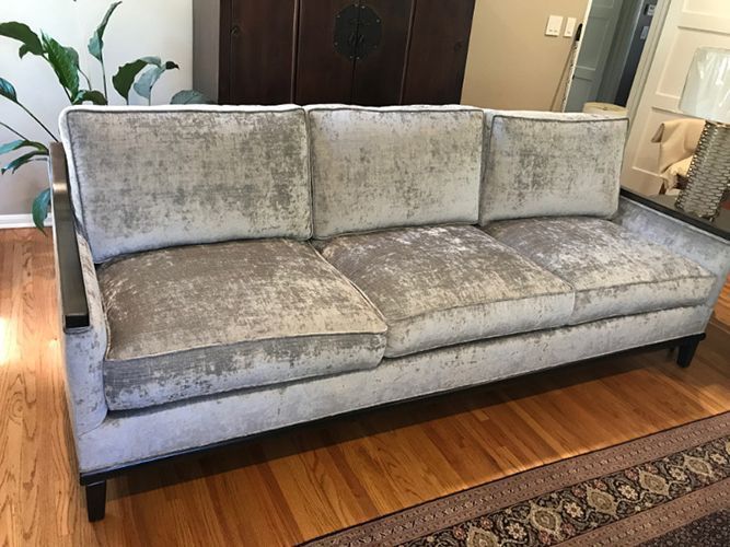 A couch is sitting on a wooden floor in a living room.