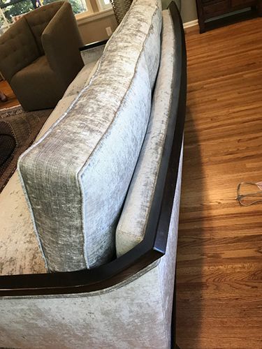 A couch is sitting on a wooden floor in a living room.