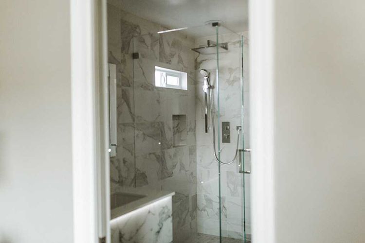 A bathroom with a walk in shower and a sink.