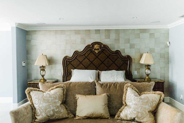 A living room with a couch and a bed in the background.