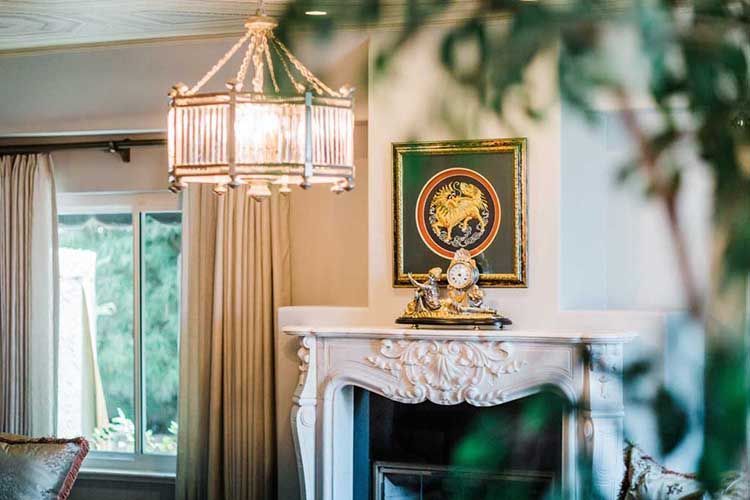 A living room with a fireplace and a clock on the mantle.