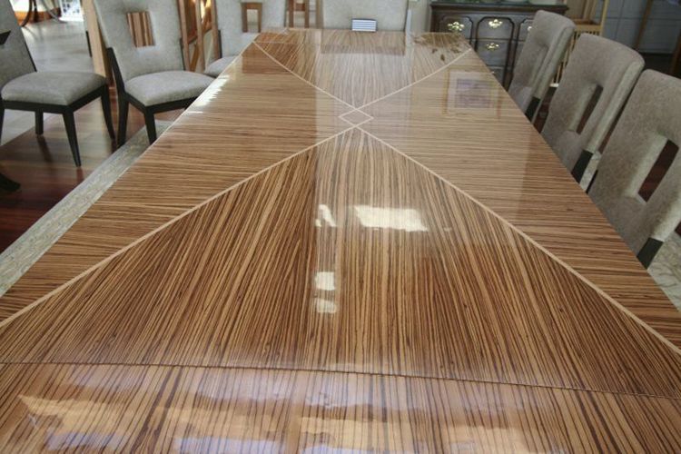 A wooden table with chairs around it in a room.