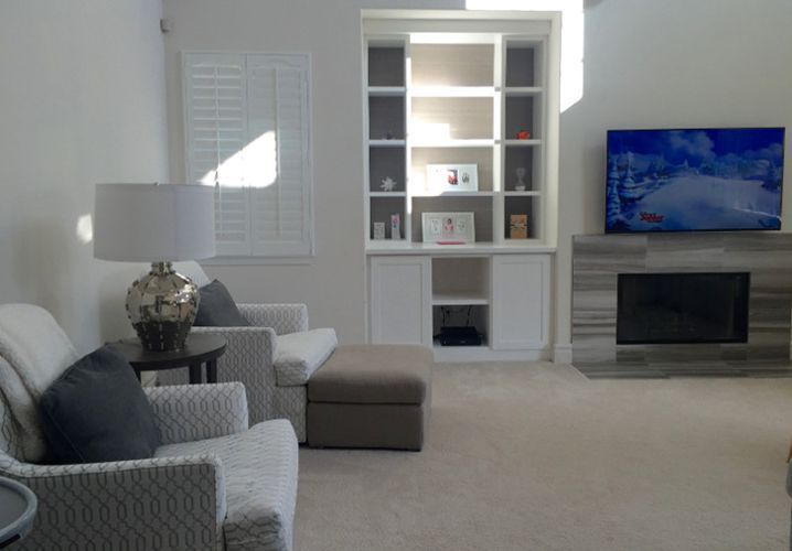 A living room with a fireplace and a flat screen tv.