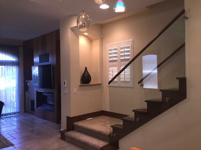 A staircase in a house with a glass railing.