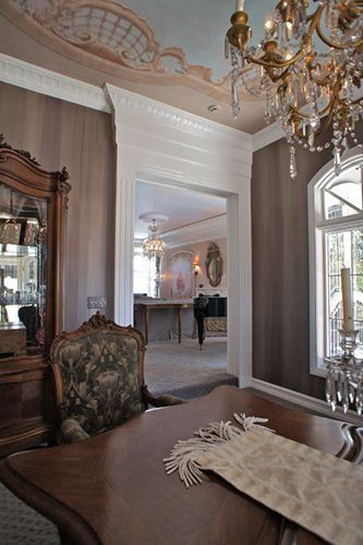 A dining room with a table and chairs and a chandelier.