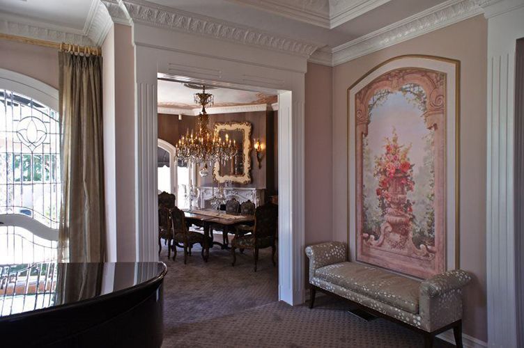 A living room with a piano and a painting on the wall.