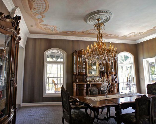 A dining room with a table and chairs and a chandelier hanging from the ceiling.