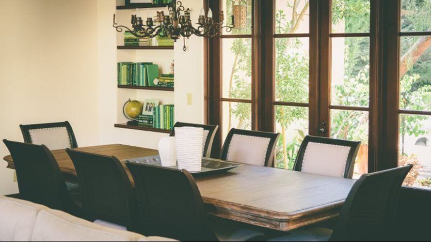 A dining room with a table and chairs and a chandelier.