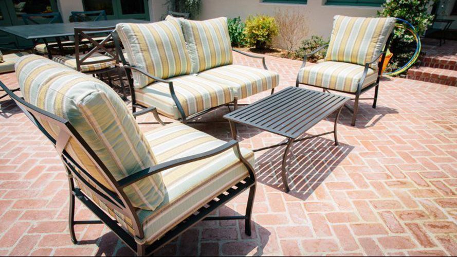 A patio with a couch , chairs , and a table.