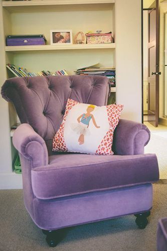 A purple chair with a ballerina pillow on it.