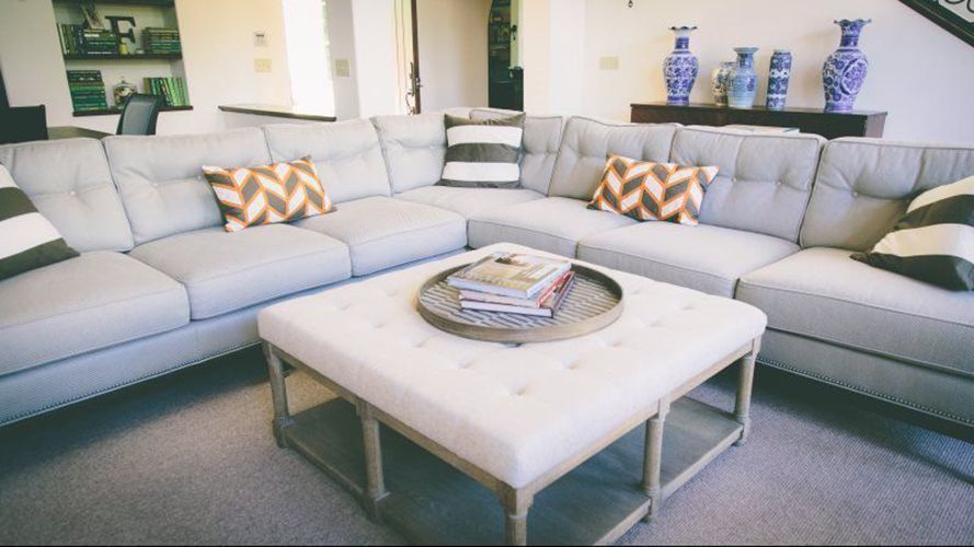 A living room with a large sectional couch and a coffee table.