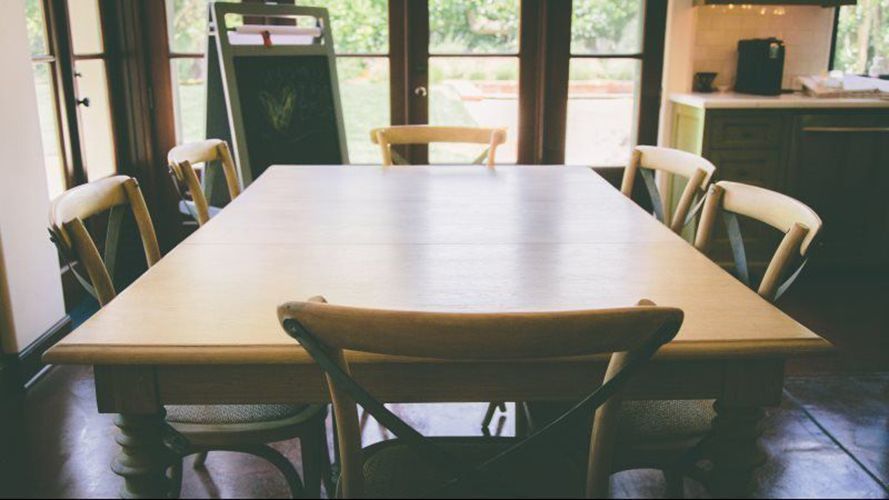 A table and chairs in a room with a large window.