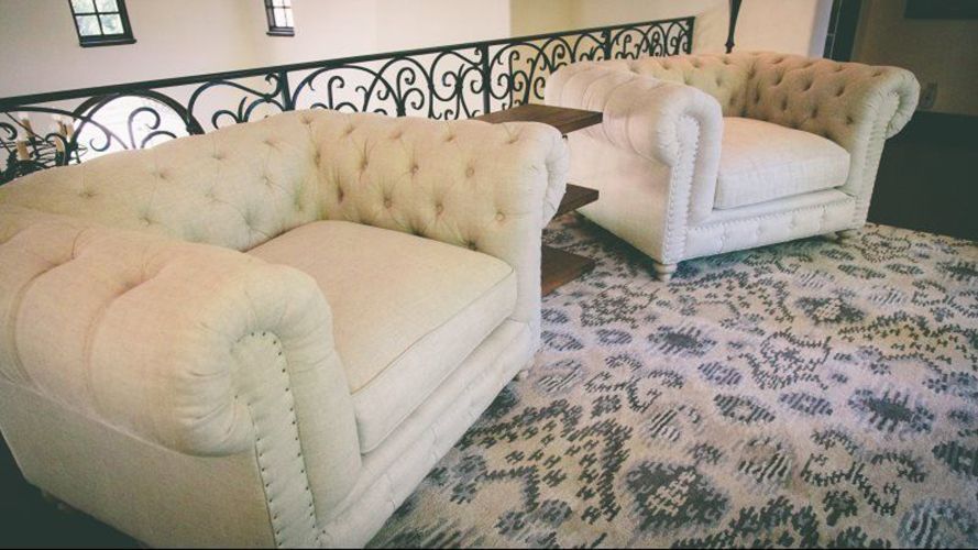 A living room with a couch and two chairs.