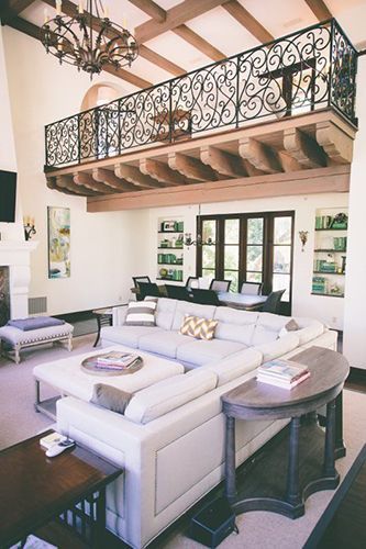 A living room with a large sectional couch and a balcony.