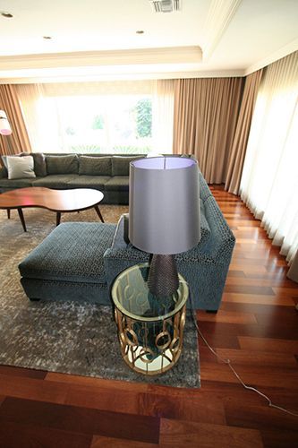 A living room with a couch and a lamp on a table.