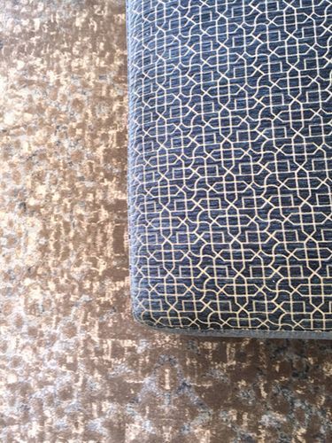 A close up of a couch and a rug with a pattern on them.