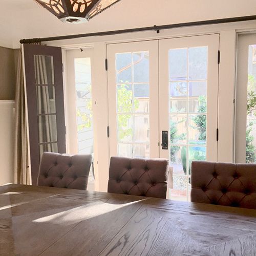 A dining room table and chairs in front of a large window.