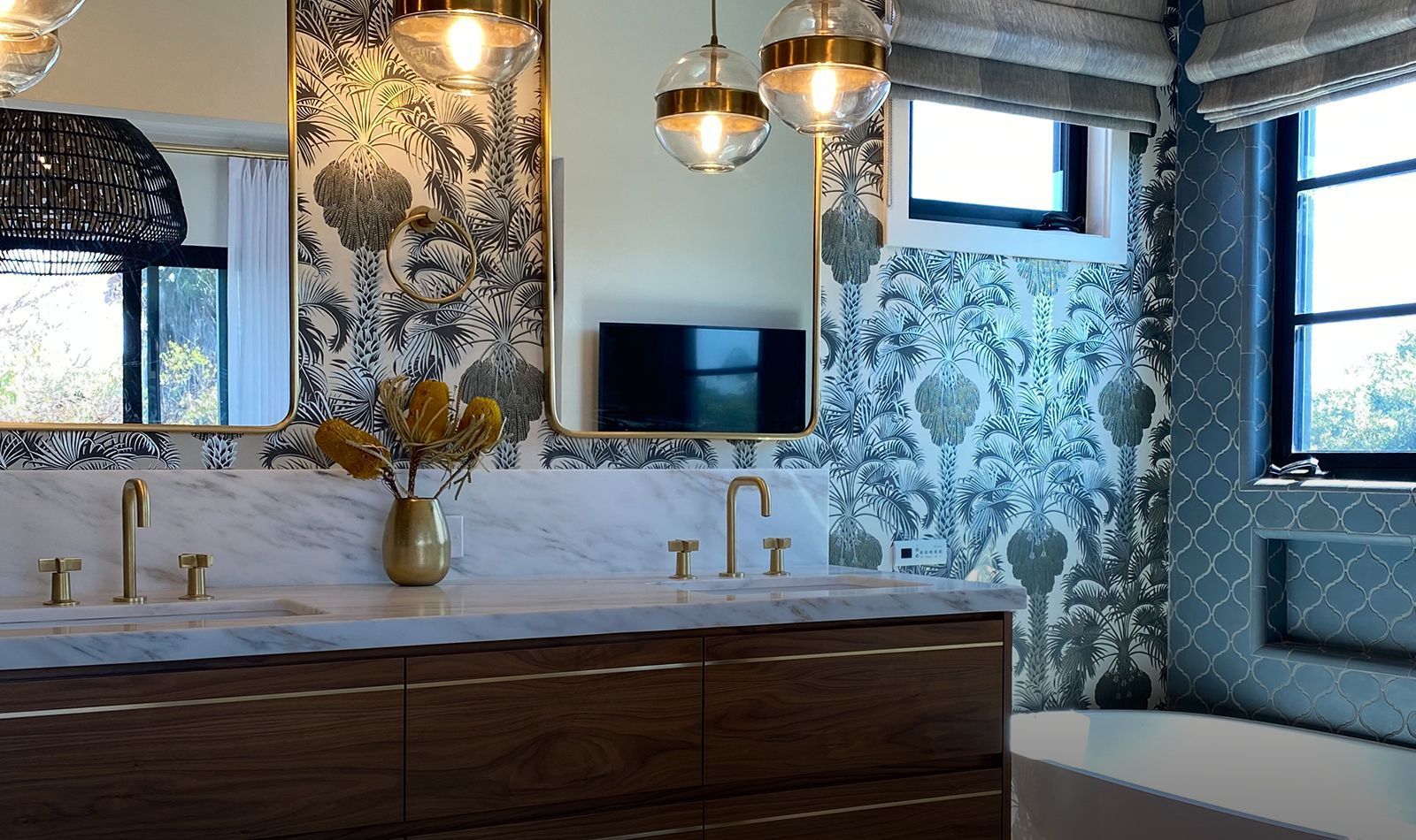 A bathroom with two sinks, a tub, a mirror and a television.