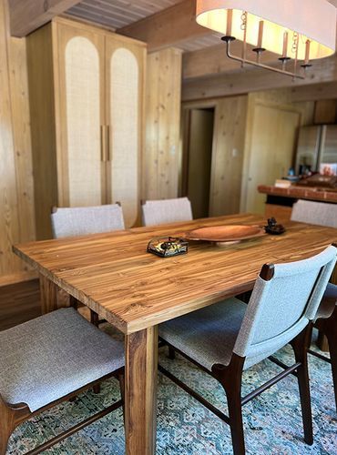 A dining room with a wooden table and chairs.
