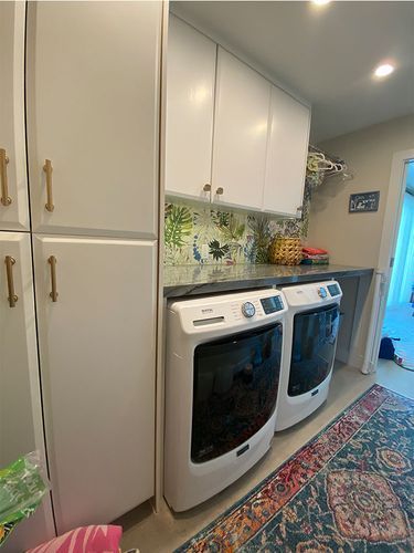 There are two washers and dryers in the laundry room.