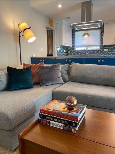 A living room with a couch and a coffee table with books on it.