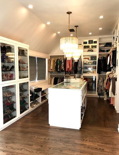 A walk in closet with a large island in the middle.