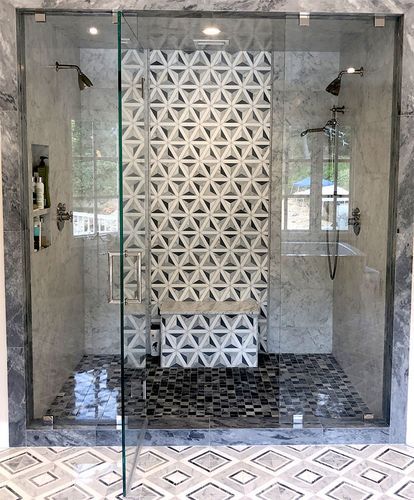 A bathroom with a walk in shower and a bench.